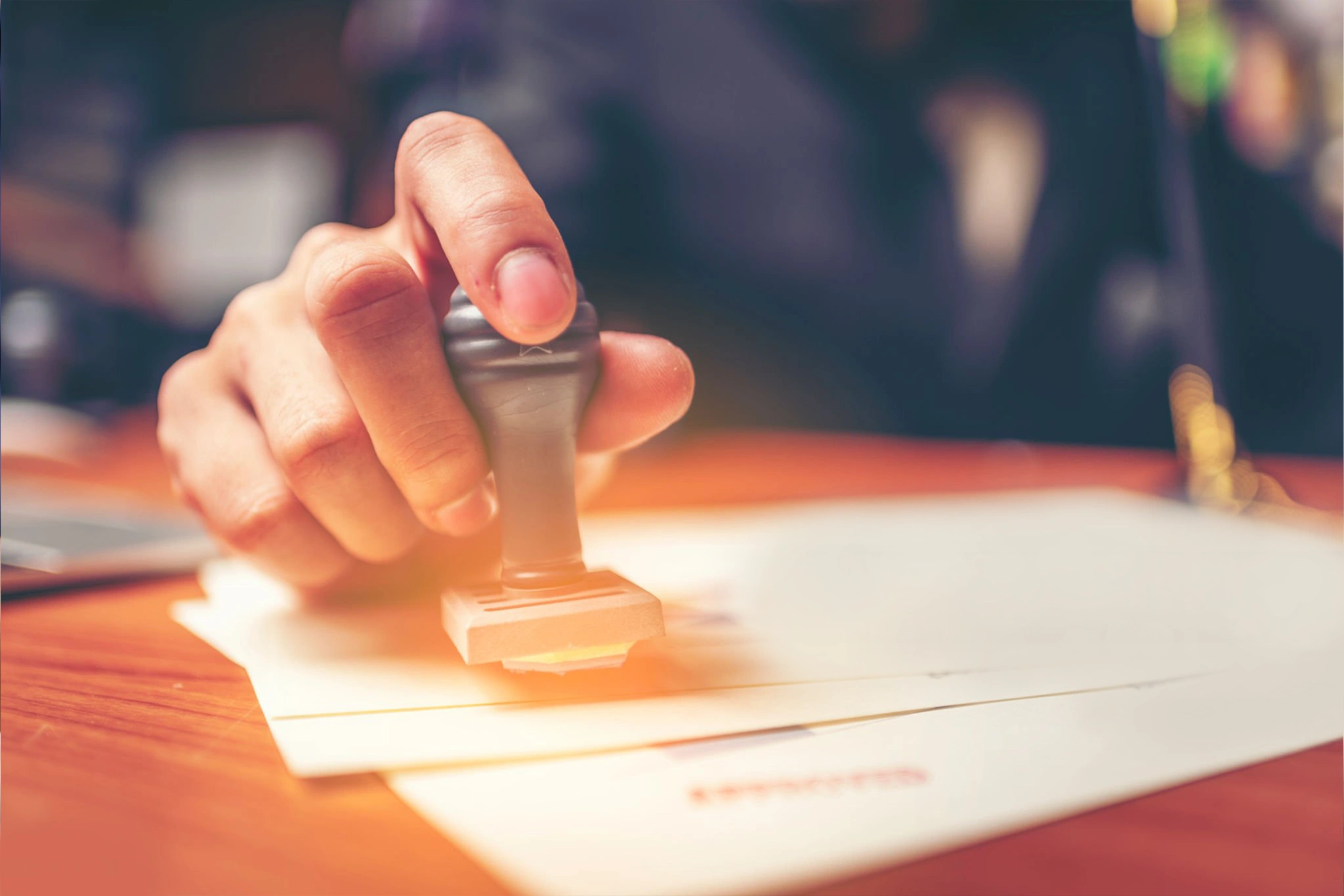 Person stamping official documents for Employment Pass and visa finalization