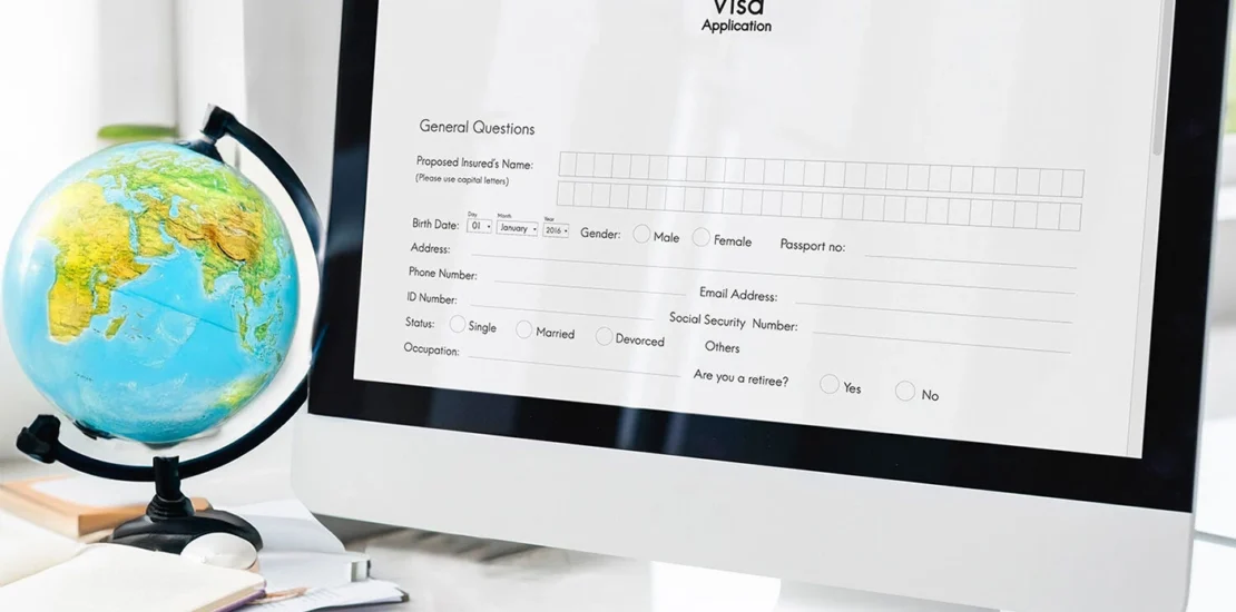 Person filling out an online visa application form on a laptop