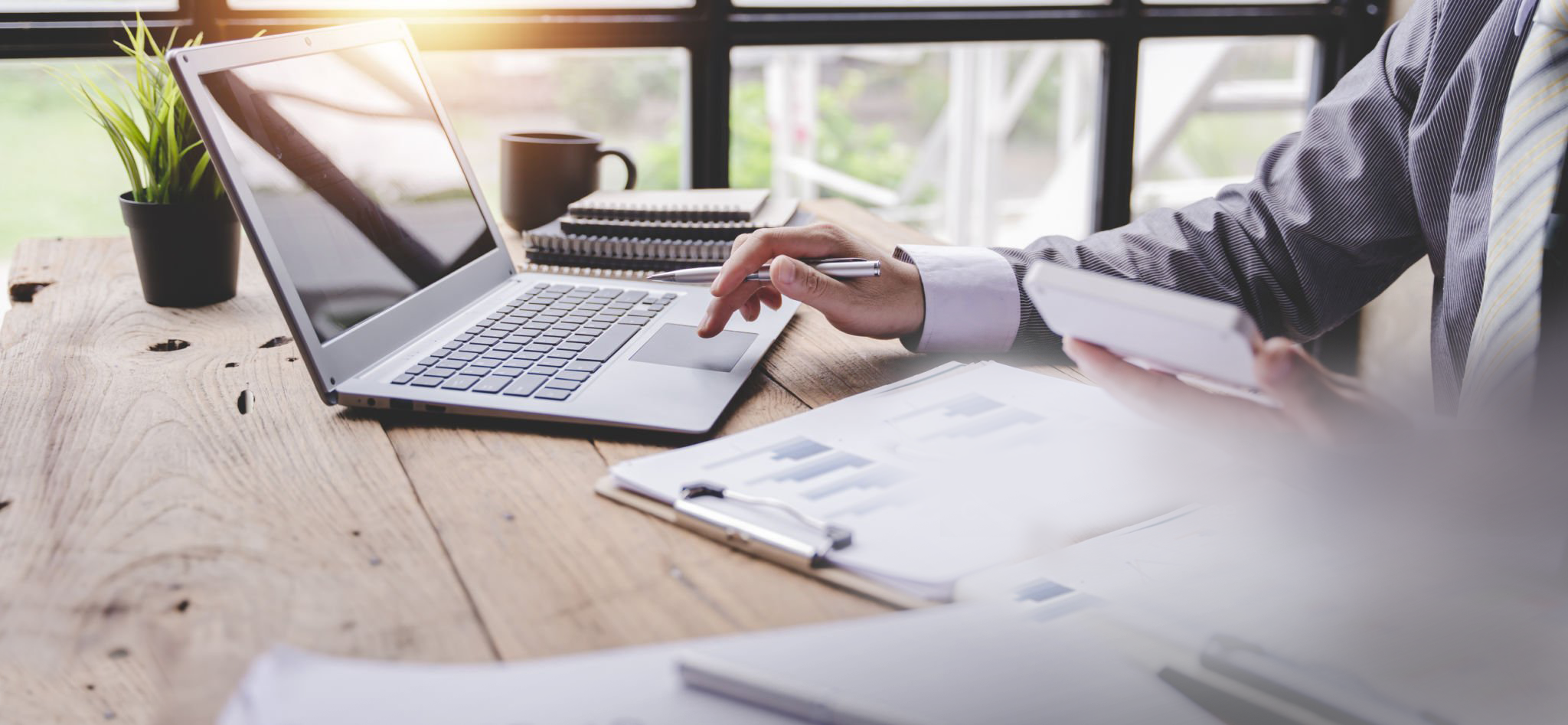 Accounting and tax documents with calculator and laptop in Singapore business setting