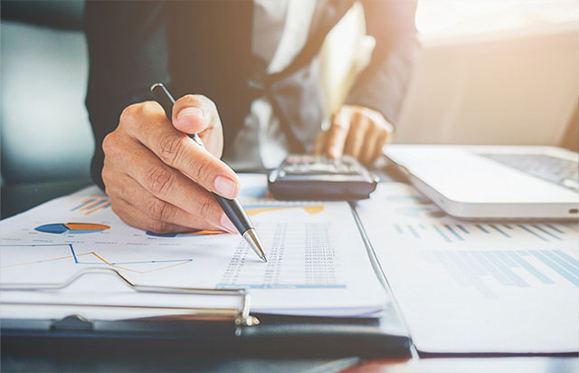 Professional working on financial calculations and signing tax documents for a client, representing Singapore accounting and tax services by Yobbi