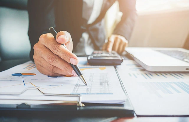 Professional working on financial calculations and signing tax documents for a client, representing Singapore accounting and tax services by Yobbi