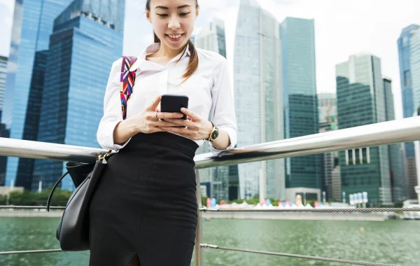 Professional woman in work attire in Singapore’s business district, representing successful visa and PR application.